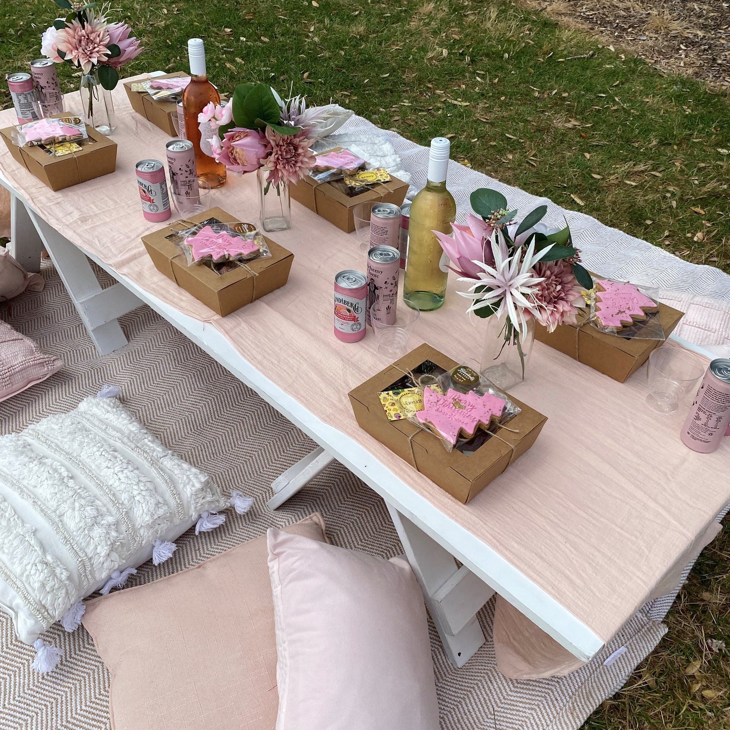 Low picnic table with food boxes, drinks and florals 