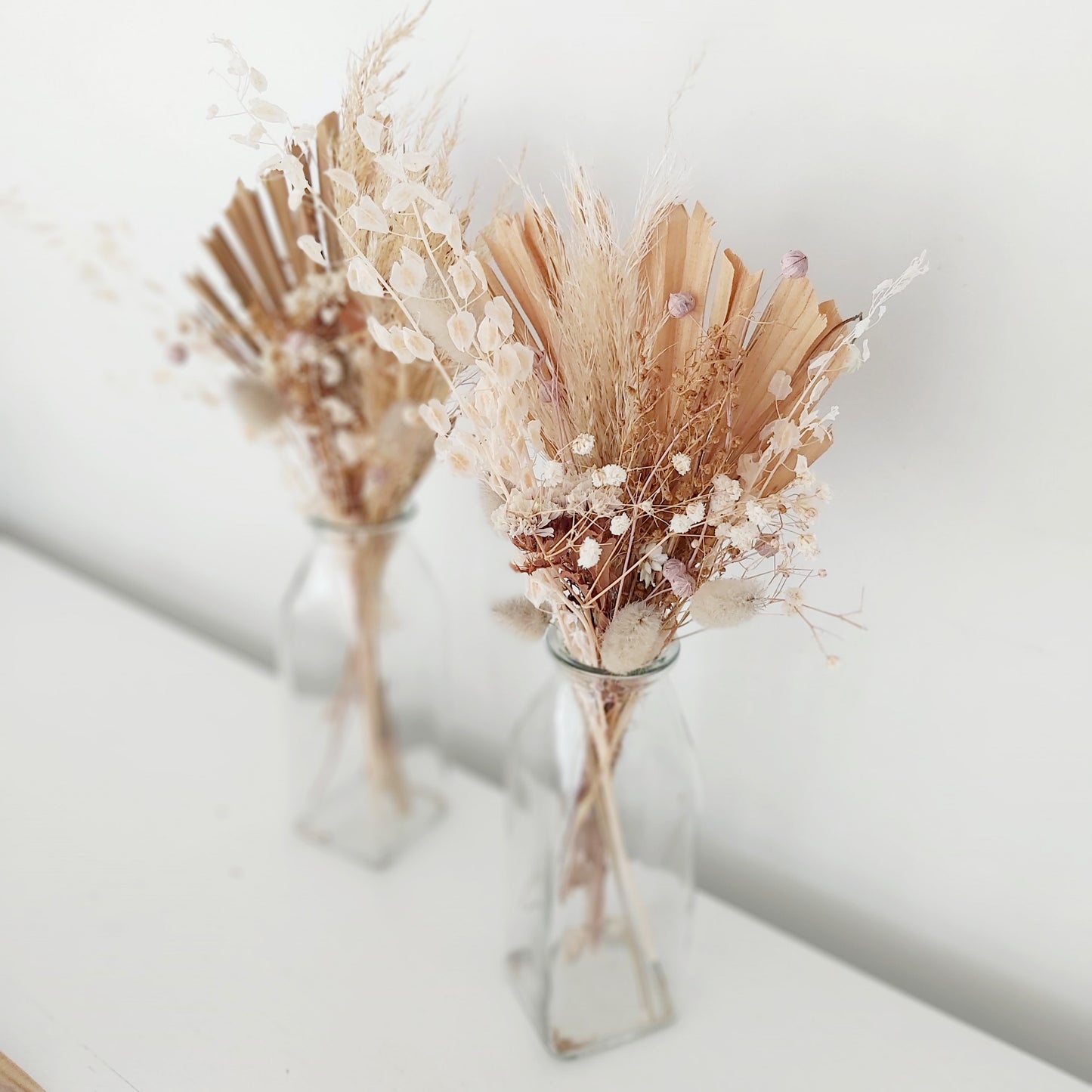 Dried floral posies in glass vases